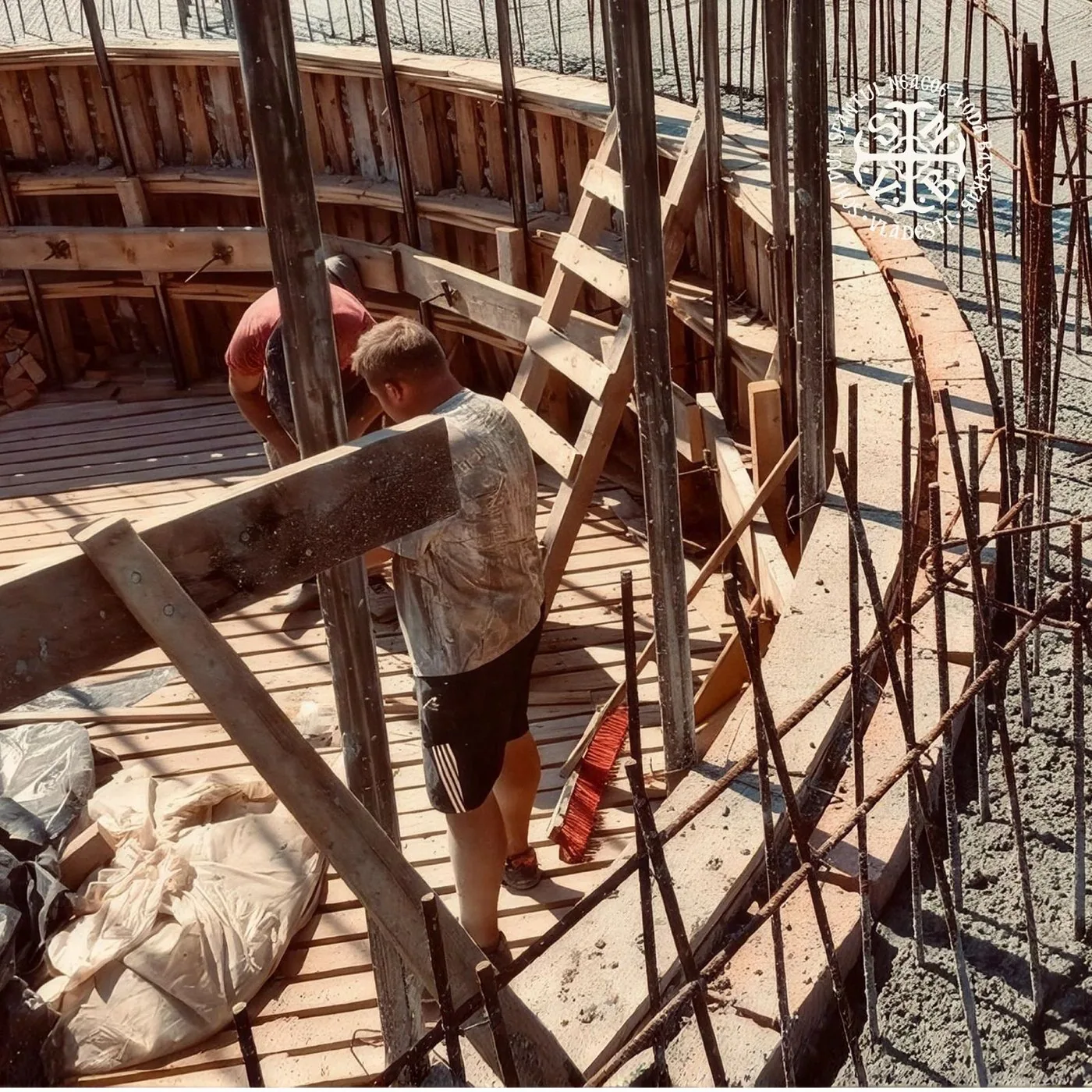 Muncitori montând cofrajele și armătura pentru turla bisericii
